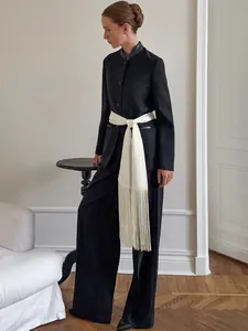 Elegant white satin sash belt with long fringes for women on a chic black suit