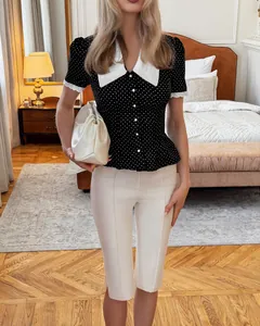 Elegante camicetta nera a pois con colletto a contrasto bianco e bottoni di perle.