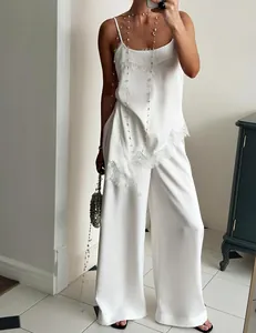 Detailed view of the elegant white lace-trimmed satin camisole and trousers set