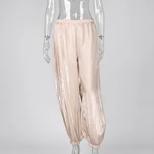 Macro shot of high-waisted champagne satin lantern pants with a luxury crinkle finish