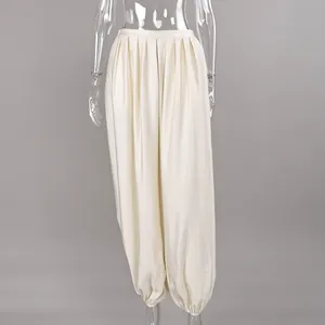 Close-up of satin fabric texture and draped harem pant design on a mannequin