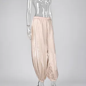 Detail view of pink shiny loose lantern pants with elastic waist and cuffs