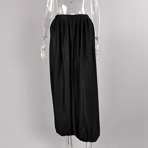 Back view of elegant black satin lantern pants featuring a draped pleated design on mannequin