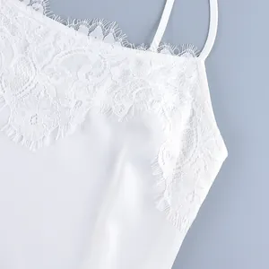 Detailed close-up showing the intricate white eyelash lace on a silky satin camisole top