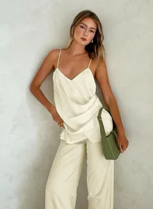 Detail shot of elegant cream satin camisole and wide-leg trousers fashion set