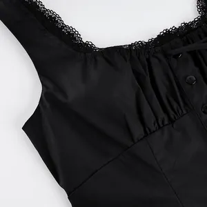 Detailaufnahme eines schwarzen Tops mit Spitzenbesatz und dekorativen Knöpfen