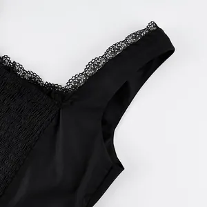 Detailansicht eines schwarzen Tanktops mit Spitzenbesatz und gesmoktem Oberteil