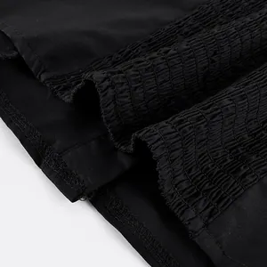 Makro-Detailansicht des elastisch gesmokten Stoffes an einem schwarzen schmalen Damentop