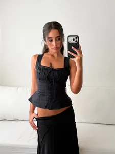 Detailaufnahme eines eleganten schwarzen Korsett-Tops mit Spitze und Knöpfen.