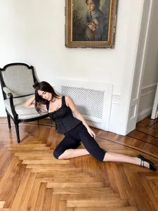 Elegante Frau in schwarzem Tanktop mit quadratischem Ausschnitt im klassischen Interieur