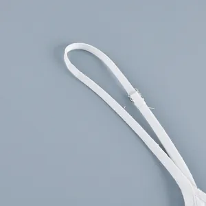 Detailed macro shot of white cotton camisole dress strap with silver flower buckle.