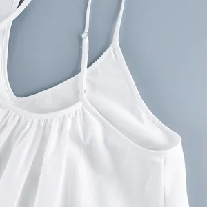 Close-up detail of adjustable shoulder straps on a white V-neck camisole dress.