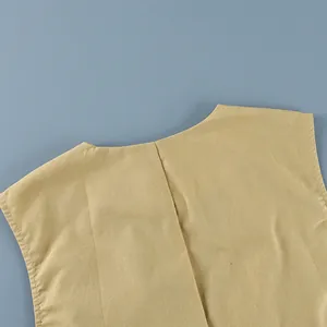 Macro detail view of the linen vest's neckline and fabric texture in beige khaki