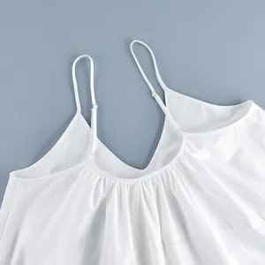Close-up of white V-neck camisole dress showing adjustable straps and pleated fabric