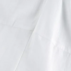 Close-up macro detail of white breathable linen fabric and clean seam stitching