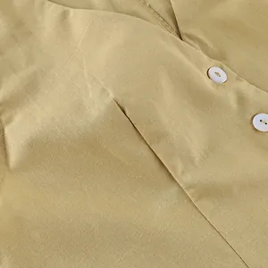 Macro detail of breathable yellow cotton linen blazer vest showing buttons and texture