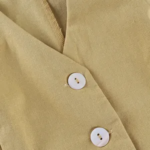Close-up detail of cotton linen vest with iridescent buttons and khaki fabric texture