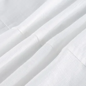 Close-up detail of breathable white linen fabric showing fine weave and soft folds