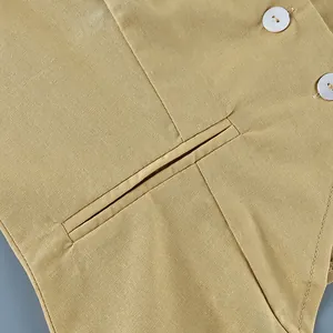 Close-up macro detail of khaki linen blazer vest with welt pocket and white buttons.
