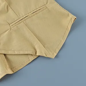 Macro detail shot showing the pocket welt and hem stitching on a cotton linen vest