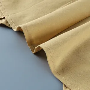 Close-up of khaki cotton linen fabric showing fine texture and neat stitching details