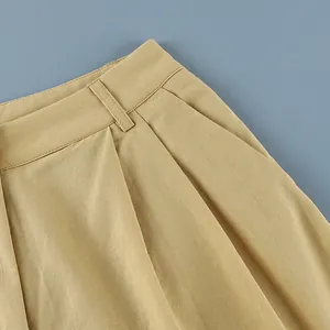 Detail view of khaki cotton linen trousers featuring pocket and waist pleats.