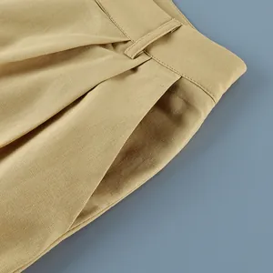 Detailed close-up of khaki cotton linen suit trousers waist showing pocket and pleats