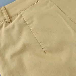 Detail macro view of khaki cotton linen fabric texture and stitching on a vest suit.