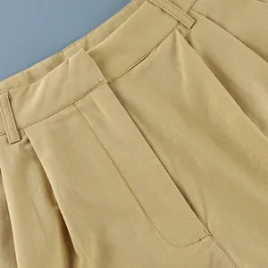 Macro view of khaki cotton linen suit trousers showing fine stitching and pleat details