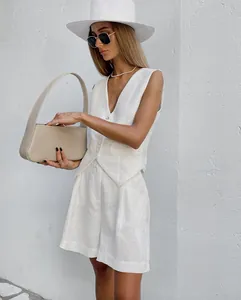 Detailed view of an elegant white cotton linen waistcoat and shorts set for summer.