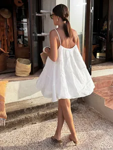 Chic white V-neck spaghetti strap mini dress in a loose A-line fit for a summer resort look