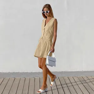 Outdoor shot of a model wearing a chic beige cotton linen vest and shorts suit set