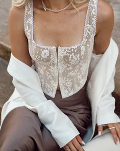 Close-up of elegant white lace corset top with delicate floral patterns and scalloped trim