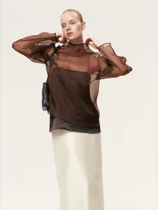 Elegante blusa marrón de malla transparente combinada con camisola y falda crema