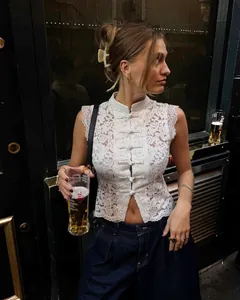 Élégant haut sans manches en dentelle blanche avec col montant et boutons chinois.