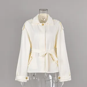 Detailed view of cream-colored faux suede trench coat with belt and lapel collar.
