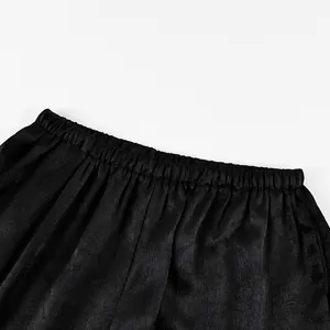 Vista dettagliata della fascia elastica in vita e del tessuto strutturato dei pantaloni neri