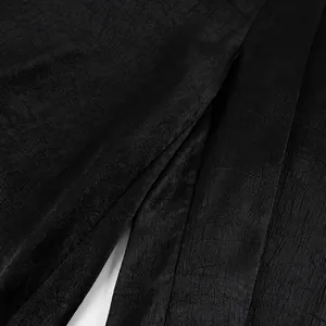 Primo piano del dettaglio del tessuto nero testurizzato per pantaloni larghi eleganti