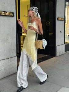 Détail d'une robe nuisette en satin jaune avec bordure en dentelle dans une rue urbaine