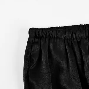 Dettaglio ravvicinato dell'elastico in vita nero su pantaloni casual da donna testurizzati
