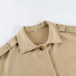 Detail of khaki trench coat showing lapel collar, epaulette, and tortoiseshell button.