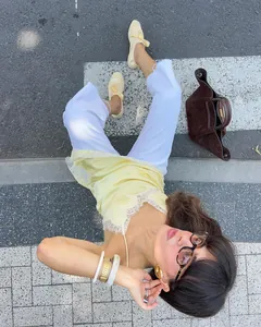 Gros plan détaillé d'une robe nuisette en satin jaune pâle avec une bordure en dentelle