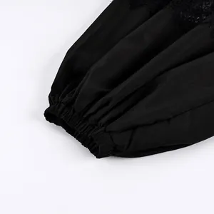 Dettaglio di pantaloni jogger neri con raffinato patchwork in pizzo e polsini elastici.