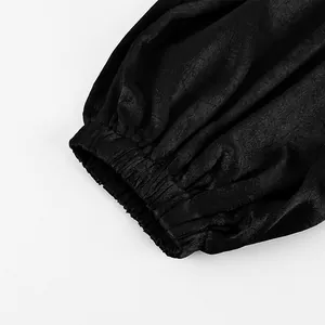 Dettaglio ravvicinato del polsino elasticizzato e della trama del tessuto su pantaloni neri