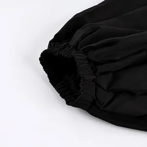 Dettaglio ravvicinato del polsino elastico arricciato sui pantaloni jogger neri