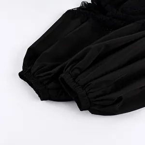 Dettaglio dell'elastico alle caviglie e del pizzo su pantaloni neri a gamba larga.