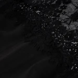 Macro dettaglio della raffinata trama in pizzo nero su questi pantaloni eleganti da donna