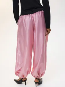 Vista posteriore di pantaloni jogger in raso rosa lucido con polsini elastici e vestibilità ampia
