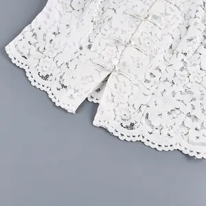 Détail rapproché d'une chemise en dentelle blanche avec des boutons grenouille