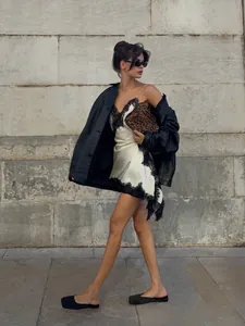 Robe nuisette élégante en satin avec dentelle noire et fente latérale discrète.